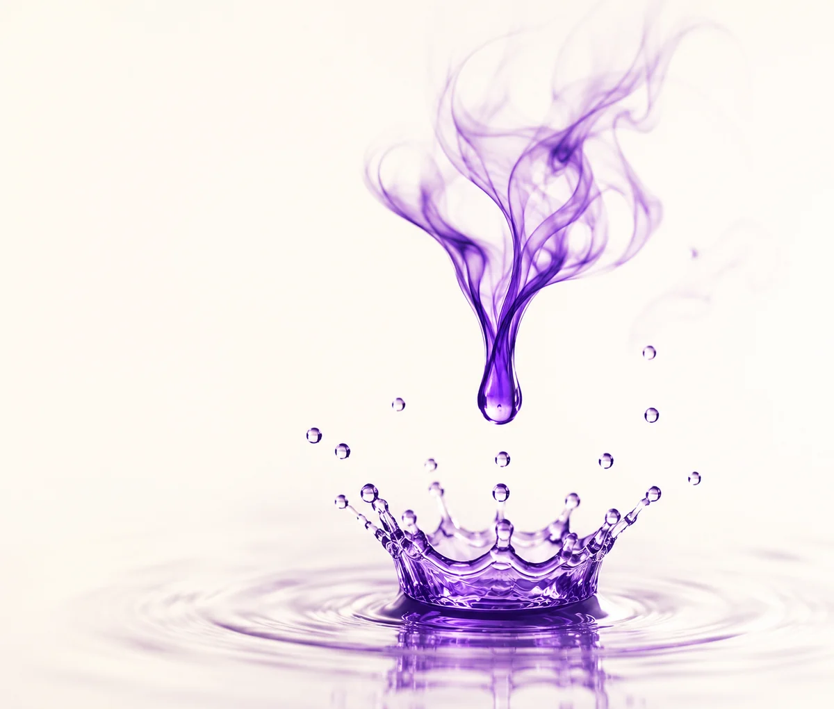 Une goutte d'encre violette qui touche l'eau et forme une couronne : la naissance d'une idée.